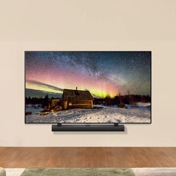 An LG TV in a living room setting displays a vivid picture of the Northern lights. A soundbar sits beneath the TV. 
