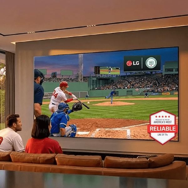 A man and woman watching a baseball game on a big screen TV.