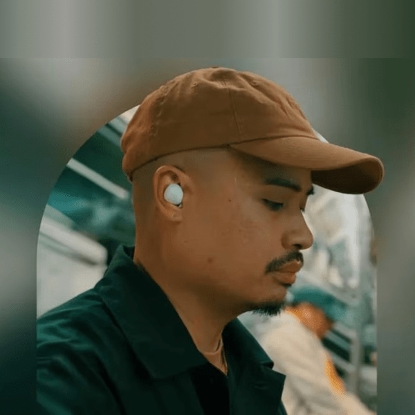 Closeup of a man wearing wireless earbuds.