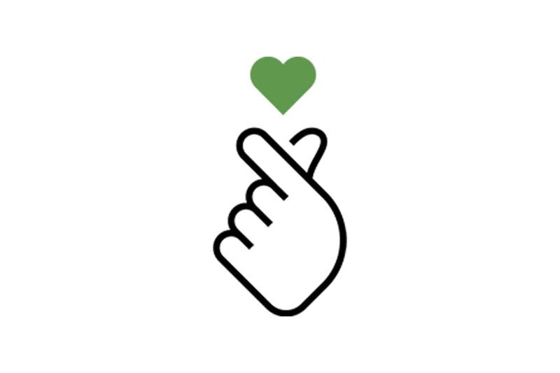 A hand making a finger heart gesture with a green heart above.