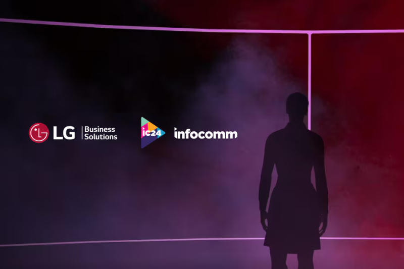 A silhouetted person standing and looking at a large video wall with a multicolored purple and red galaxy displayed on it. The logos for LG Business and Infocomm are to the person's left.