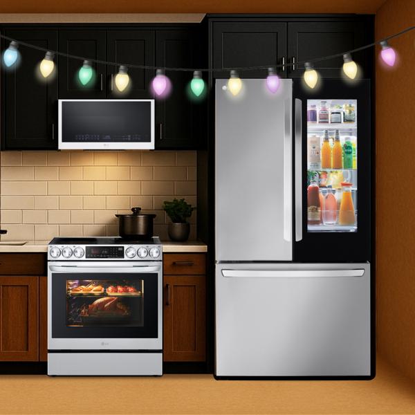 An LG over-the-range microwave, range, and InstaView refrigerator in a cozy kitchen decorated for the holidays.