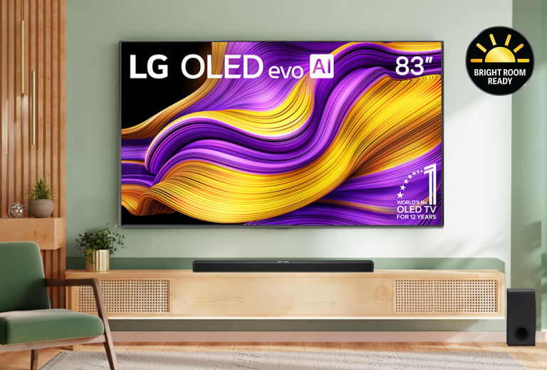 A modern living room featuring an 83-inch LG OLED evo AI TV mounted on a green wall. The TV displays a vibrant abstract image with purple and gold waves. A wooden console with a soundbar and a speaker is placed beneath the TV. The room is decorated with a mint green armchair, potted plants, and wooden paneling. A "Bright Room Ready" badge is visible in the top right corner.