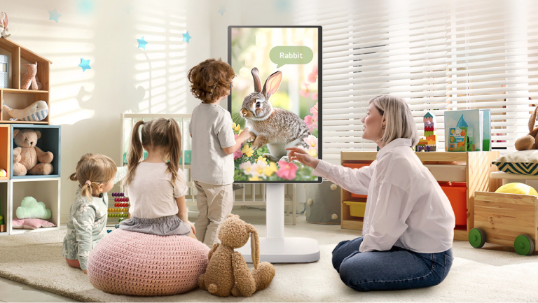 Woman and children interact with an LG Monitor Swing in a bright playroom.