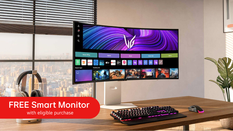 A widescreen monitor on a desk within an office. “Free smart monitor with eligible purchase” text above.