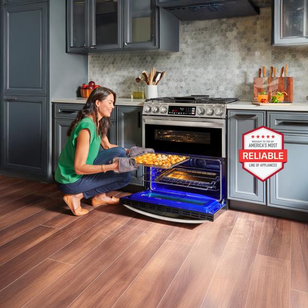 A woman removes fresh baked pastries from an LG range in a bright kitchen setting.