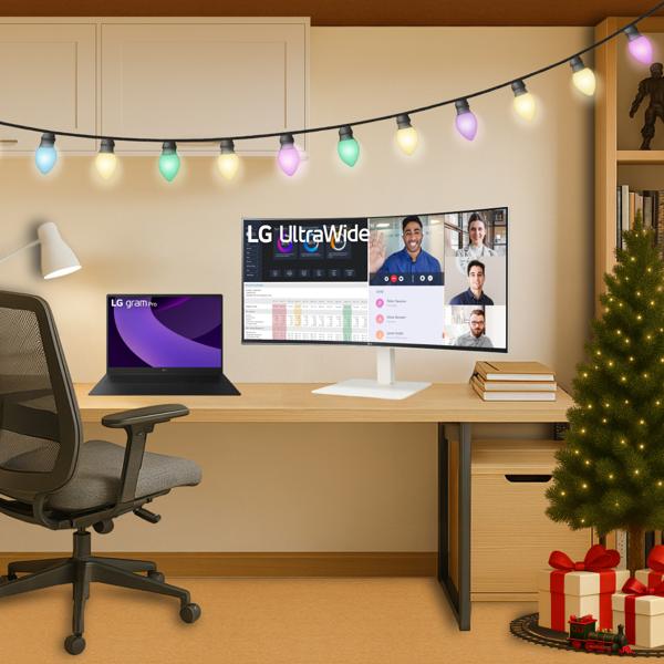 An LG monitor and laptop sit on a desk in a home office decorated for the holidays.