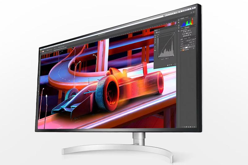 Monitor displaying digital artwork of a stylized race car on a futuristic track.