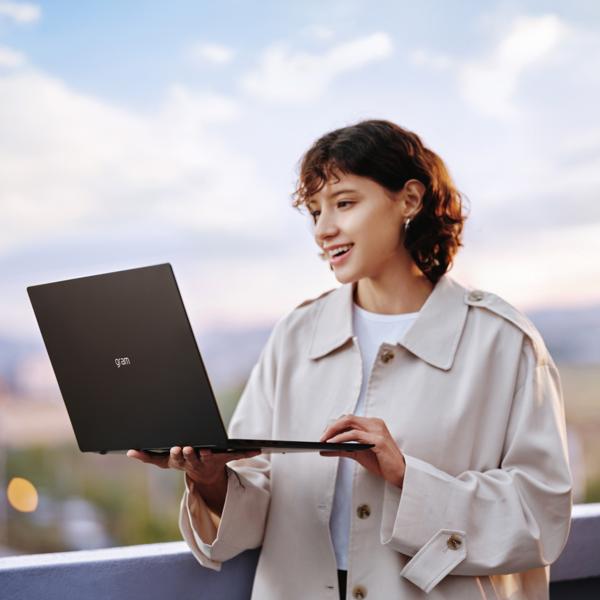 Woman using the LG 17" Gram Pro Laptop outside.