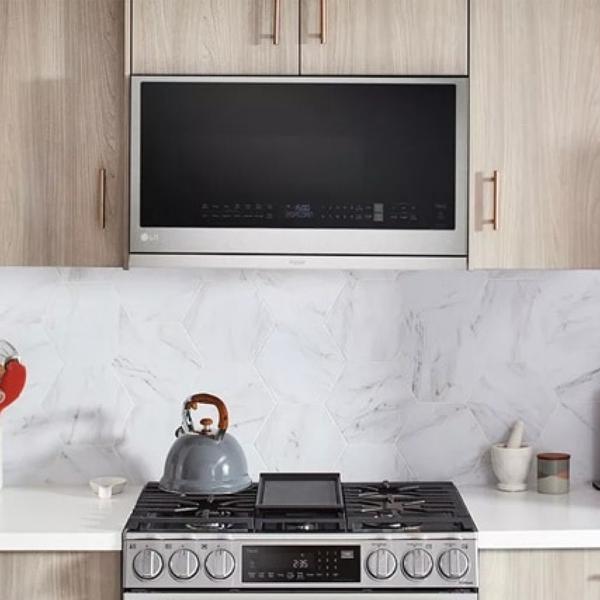 The Smart Over-the-Range Microwave in a sleek, white kitchen with an LG range below it.