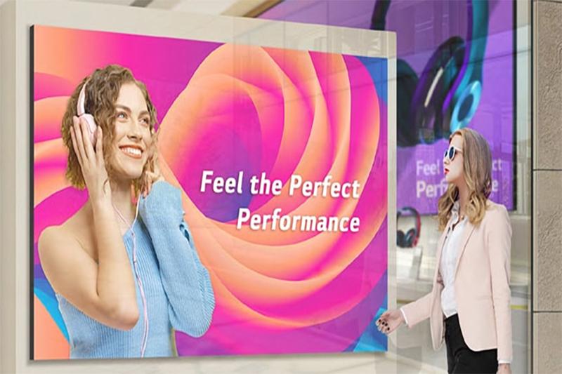 Woman with headphones on a colorful billboard, another woman observing.