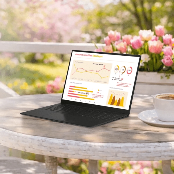 An LG gram Laptop sits open on a white outdoor café table beside a cup of coffee, displaying a colorful analytics dashboard with charts and graphs. Pink tulips bloom in the background, creating a bright spring setting. A purple “Spring Savings” badge appears in the top left corner of the image.