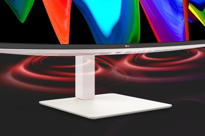 Curved monitor displaying colorful abstract patterns on a white stand.