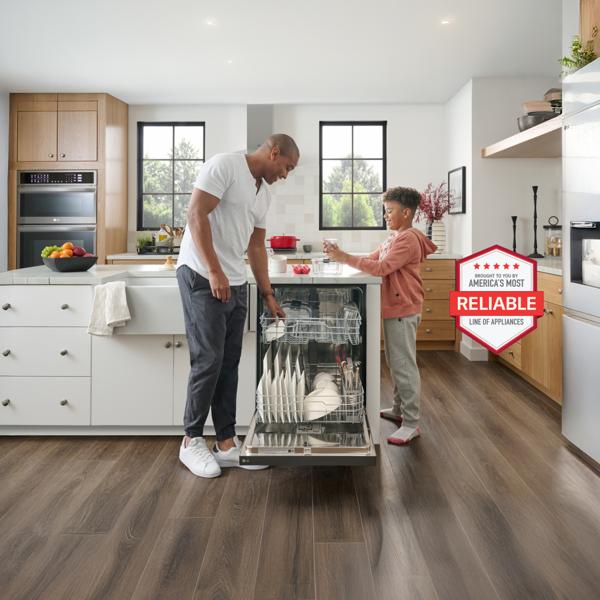 A father and son load an LG dishwasher in stylish kitchen setting.