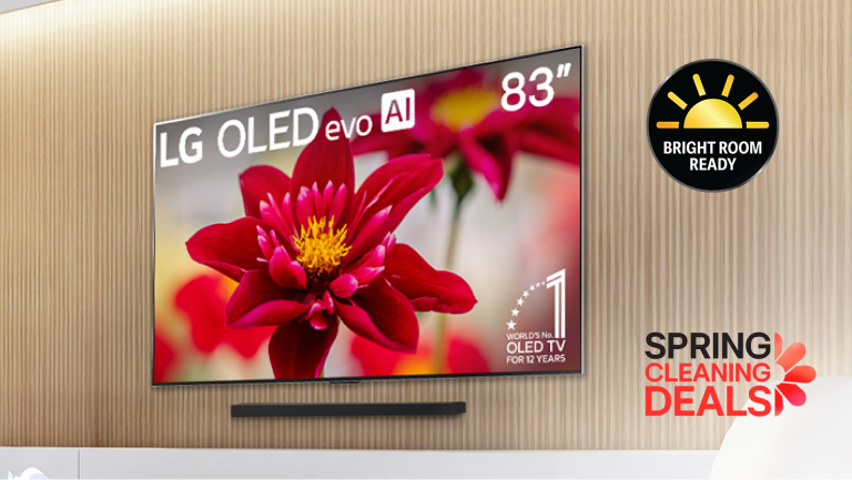 Contemporary living room with an 83-inch LG OLED evo AI TV mounted on a wood-paneled wall, displaying a vivid red flower, with a “Bright Room Ready” badge and “Spring Cleaning Deals” promotion.