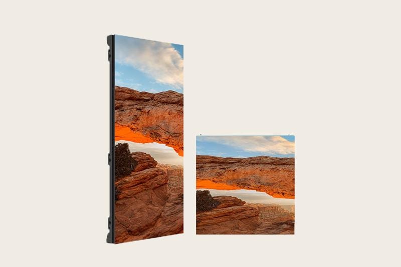 Two electronic display screens showing a landscape of a rocky arch against a blue sky with clouds.