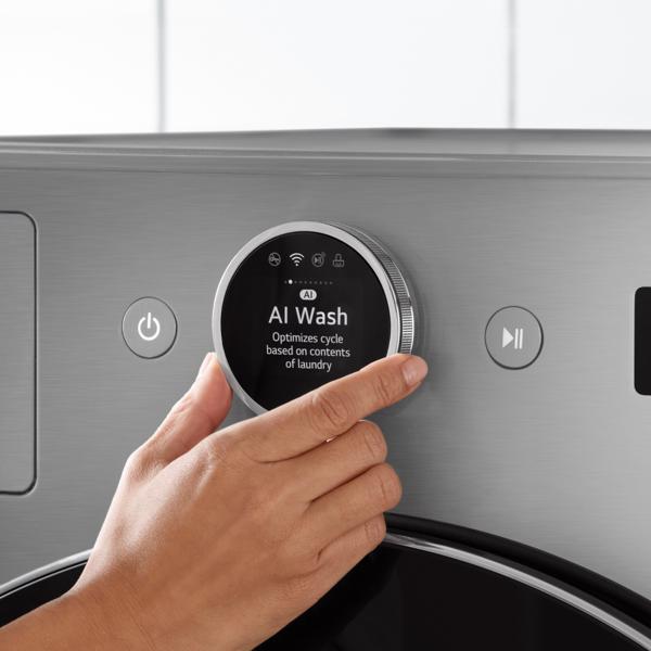 Close-up of a hand adjusting the dial on an LG washer to “AI Wash”.