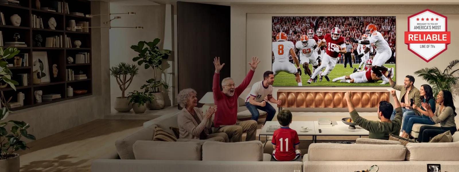 Family and friends cheer while watching a football game on a large wall-mounted TV in a modern living room. A “America’s Most Reliable Line of TVs” badge appears in the upper-right corner.