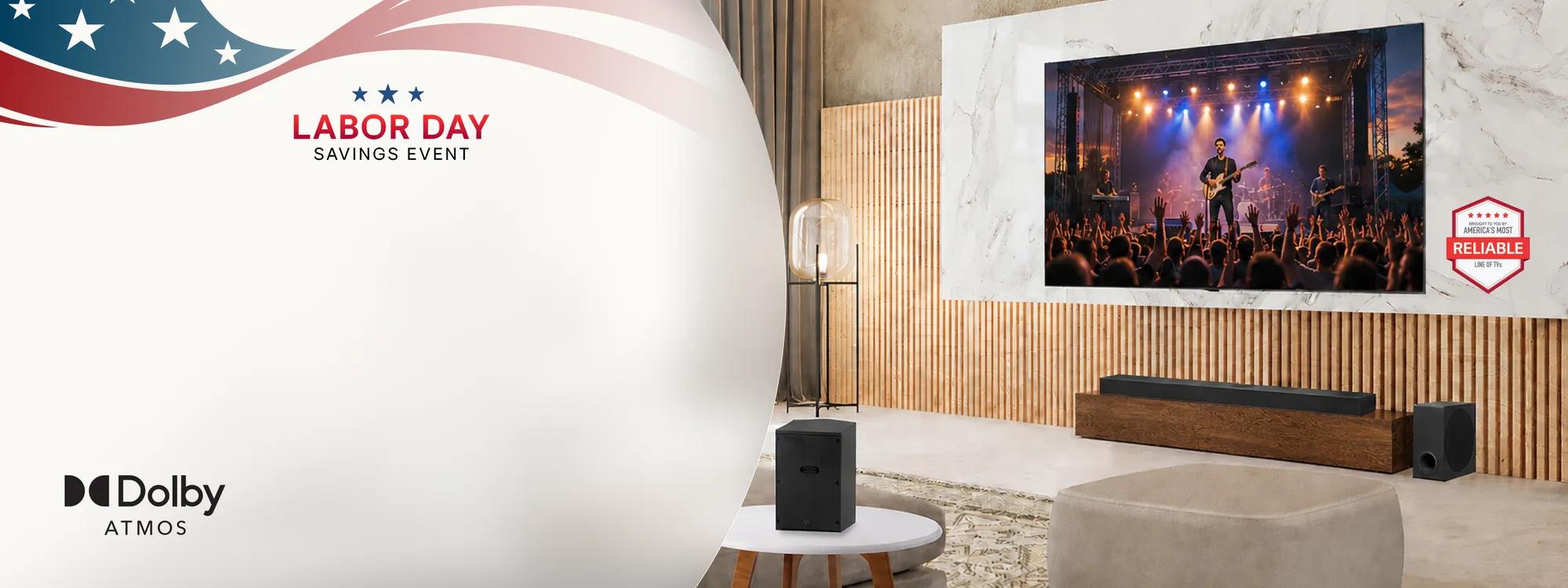 Labor Day Savings Event featuring an LG TV mounted on a marble wall displaying a live concert, an LG Soundbar on a wooden media console, a subwoofer, and an LG speaker on a side table in a modern living room, with Dolby Atmos logo and America's Most Reliable Line of TVs badge visible.