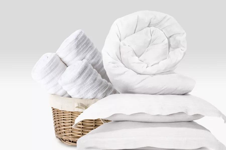 Laundered comforter, pillows and towels in basket