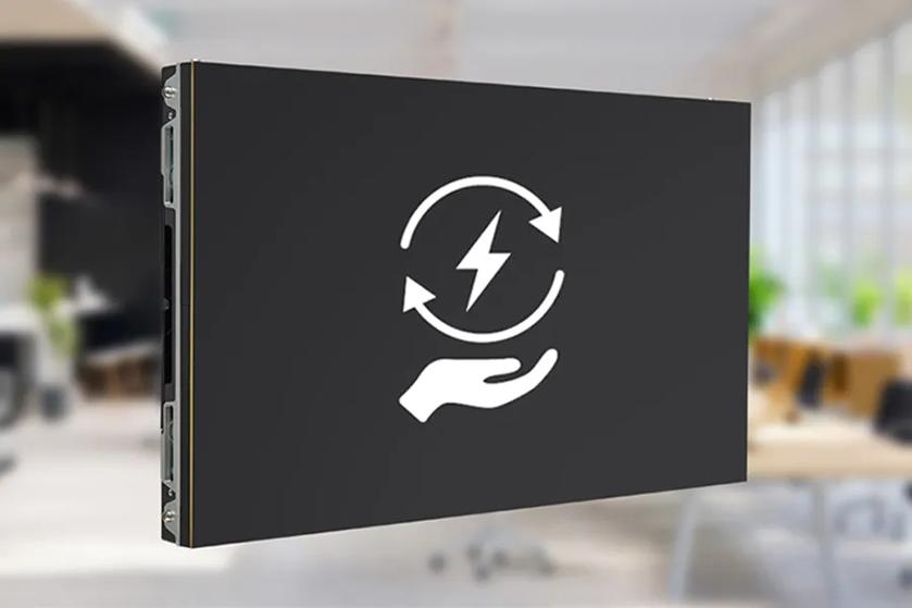 Rectangular electronic device with an energy-related icon, set against a blurred office background.