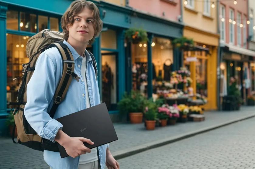 A professional carries an LG gram laptop under his arm in the city