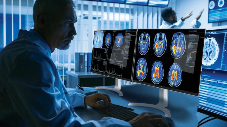 A doctor looks at brain scans on an LG diagnostic monitor
