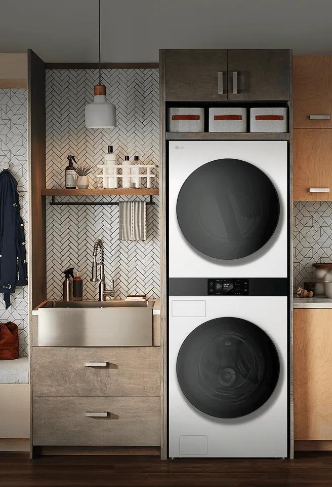 LG built-in stacked washer and dryer in a modern laundry room with wood cabinetry and bench seating.