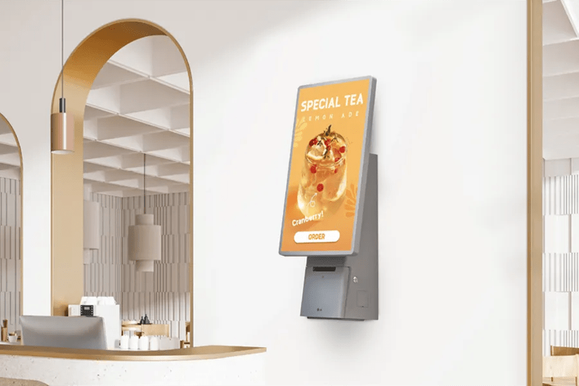 Cafe interior with a digital display showing a "Special Tea: Lemon Ade" advertisement.