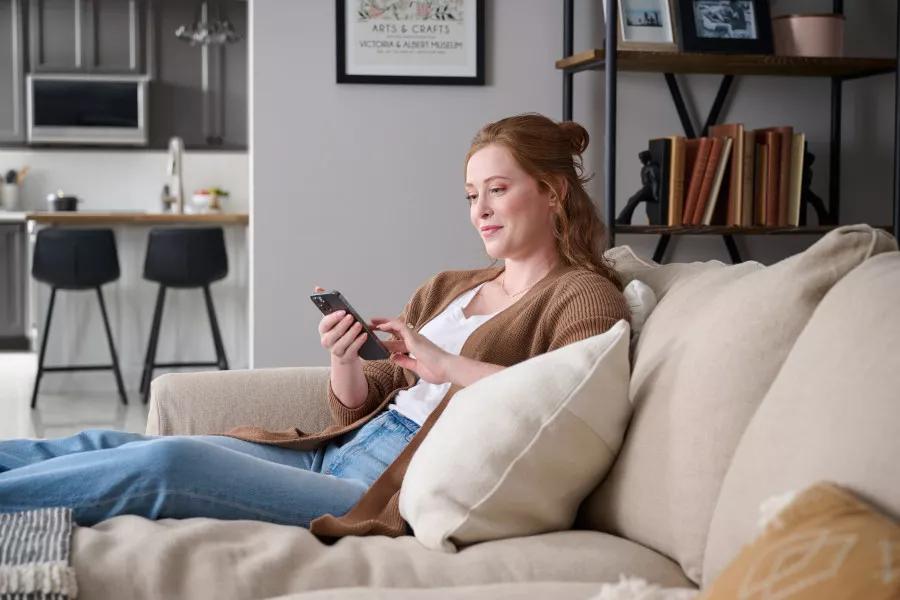 ThinQ HMLH App Phone on Couch With Female