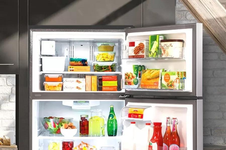 Open LG refrigerator filled with food highlighted by sunlight in a kitchen