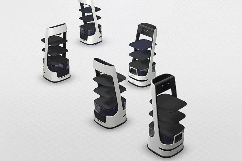 Five CLOi robots facing different directions with cheerful looks on their displays.