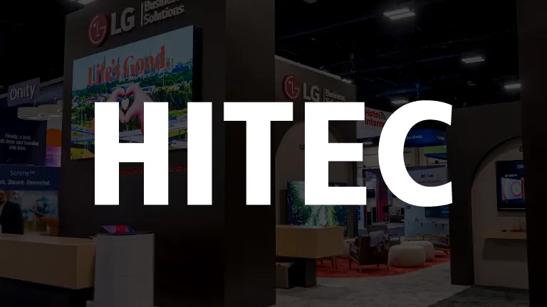 A photo of LG's booth at HITEC 2024, darkened and with the HITEC show logo in white over it.