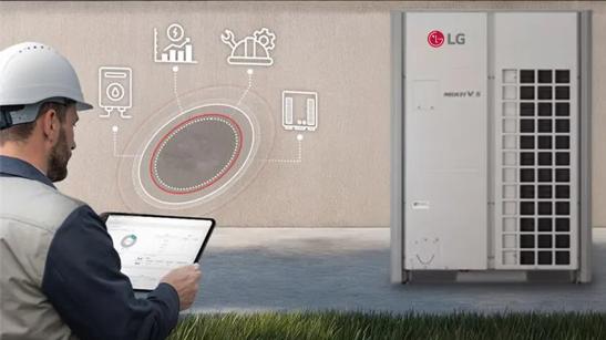A builder works on an LG HVAC system, looking at a tablet full of diagnostics while the LG HVAC stands against a building.