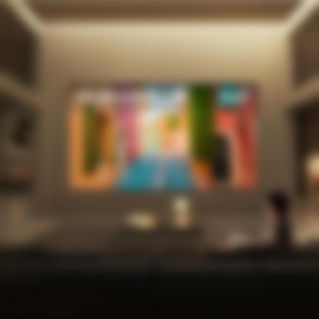 A man watches his Micro RGB TV from a couch in a stylish living room setting. “America’s Most Reliable Line of TVs” badge.