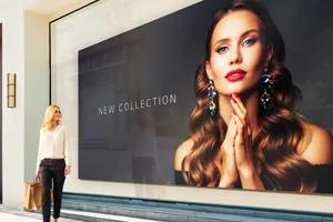 A woman looks at a large direct view led display advertising jewelry.