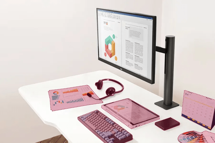 A clean white desk with an LG ergonomic monitor on a clamp stand on it. Other items rest on the desk's surface, such as a keyboard, a pair of headphones, paperwork, and a desktop calendar. These items are colored with a red overlay and have a dashed red line outlining them, indicating that they're just possible items you could keep on your desk thanks to the space-saving Ergonomic Monitor.
