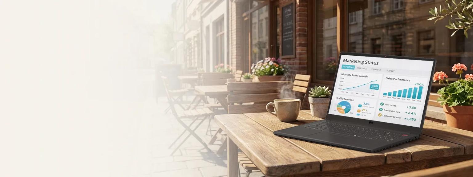An LG gram Laptop sits open on a white outdoor café table beside a cup of coffee, displaying a colorful analytics dashboard with charts and graphs. Pink tulips bloom in the background, creating a bright spring setting.