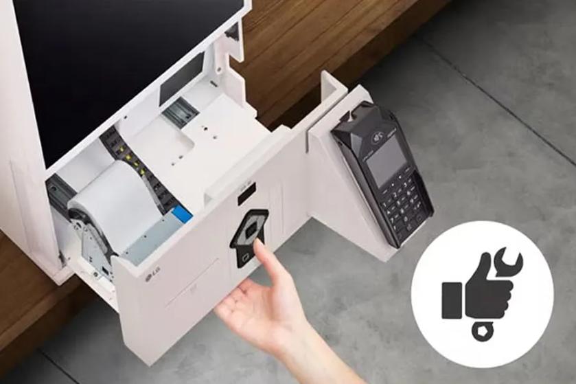 Open compartment in a payment terminal with receipt paper and keypad.