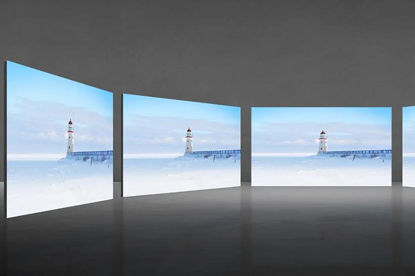 Four screens displaying a winter scene with a lighthouse and pier in a snowy landscape.