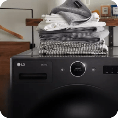 A stack of linens rests on top of a ThinQ®-enabled LG washer.