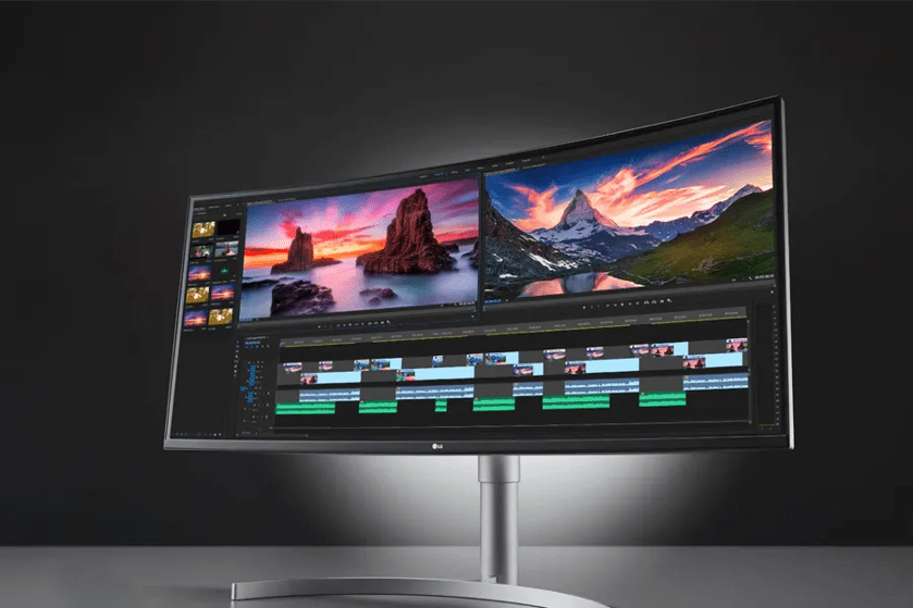 A large curved monitor displaying landscape images and video editing software.