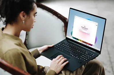 A woman seated on a chair, working on a LG laptop, powered by Copilot AI.