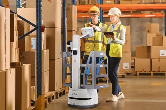 CLOi assists two workers in a large warehouse.