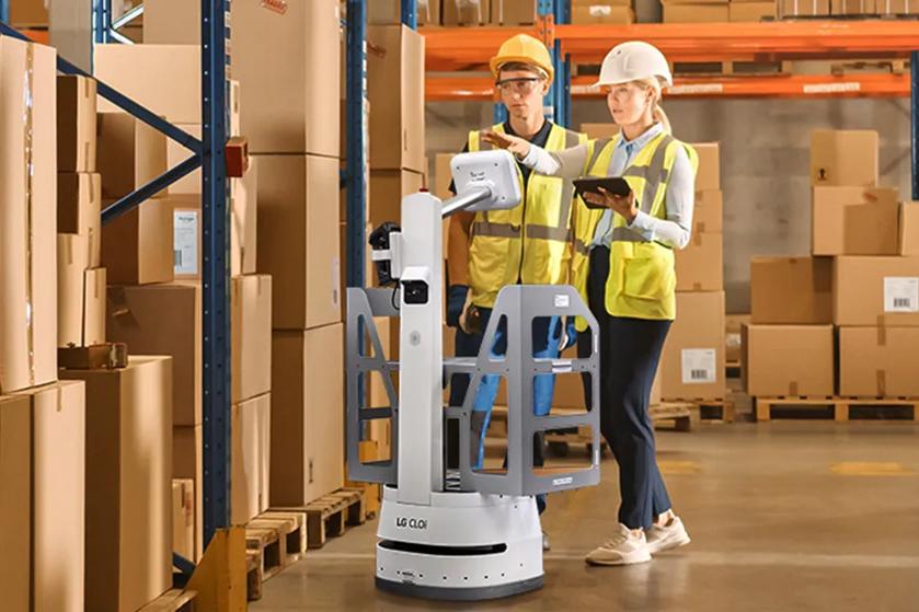 CLOi assists two workers in a large warehouse.