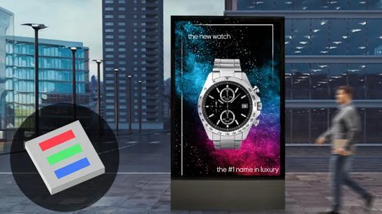 A man in a city is walking past a DVLED display, advertising a luxury watch. In the bottom left corner is an illustration of a Chip On Board type DVLED pixel. 