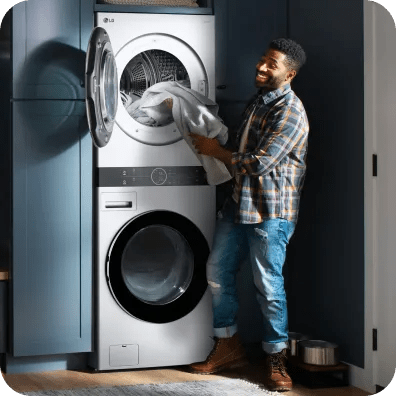 A man loads linens into the top dryer of an LG WashCombo™.