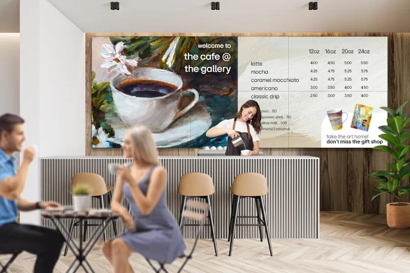 A museum cafe with an LG video wall advertising the menu and gift shop.