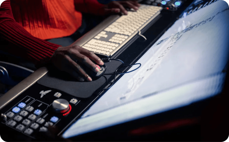 Will.i.am hand holding a mouse in front of a computer screen