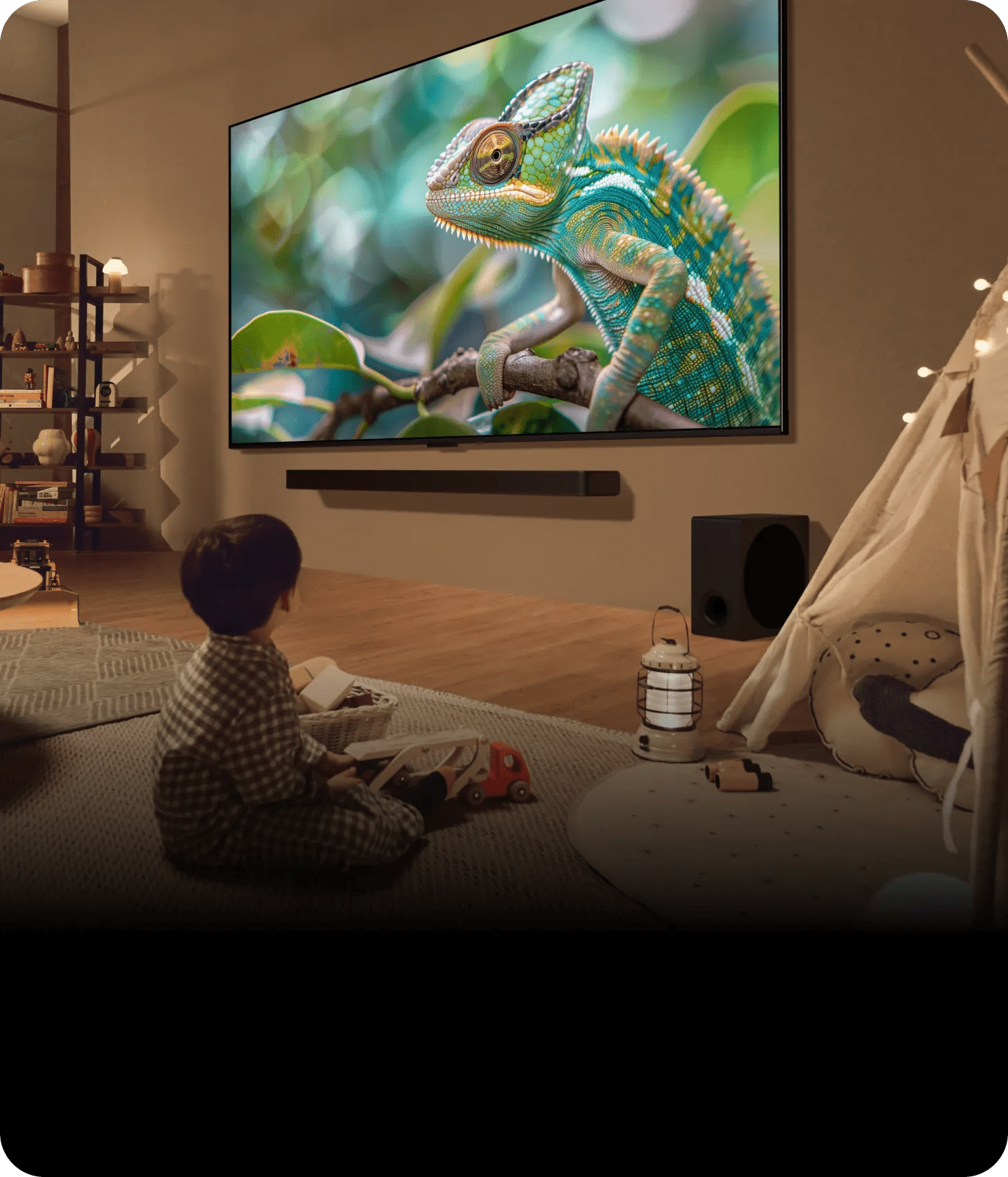 A child sits on the floor, captivated by a movie playing on the television in a cozy living room setting.